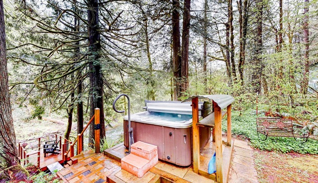 Unwind in nature's embrace at a 1925 cabin with hot tub & river views